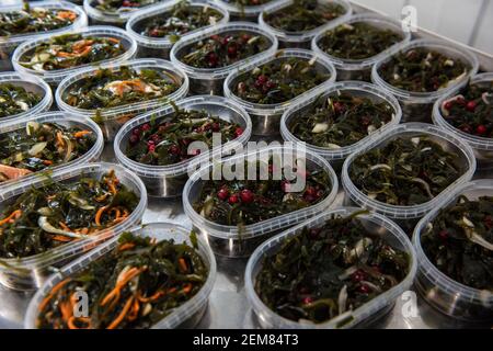 Différentes salades d'algues de poisson et de chuka wakame laminaria en plastique bowles. Concept de production ou de livraison de nourriture saine Banque D'Images