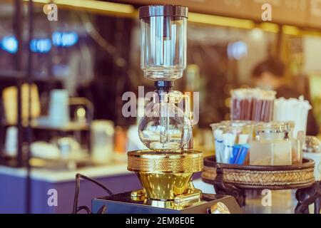 Gros plan sur la préparation du café par le barista à l'aide de la machine à café avec pot à vide. La machine à café Syphon (Siphon) prépare des boissons en utilisant deux chambres où la pression de vapeur et v Banque D'Images