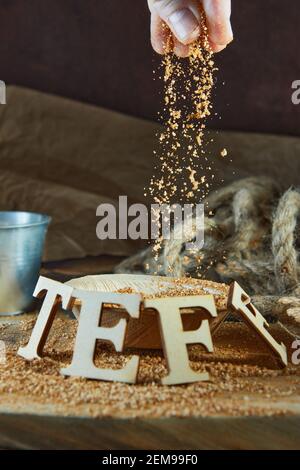 Teff, une alternative à l'ancien grain sans gluten avec le nom écrit en lettres de bois. Mettre les farines dans le seau. Banque D'Images