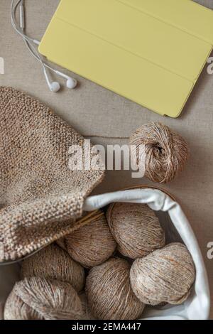 Artisanat et tricotage à la maison. Clubs de fil et un foulard crocheté dans un panier. Vue de dessus, mise au point sélective. Banque D'Images