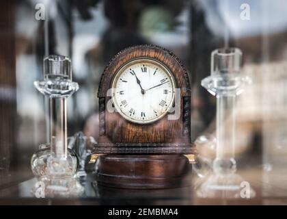 Ancienne horloge mécanique en bois se tenant dans un magasin d'antiquités fenêtre avec des reflets sur le verre indiquant l'heure de la onzième minute 11:11 11ème heure Banque D'Images