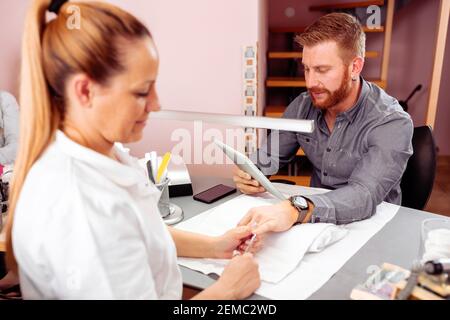 Manucure pour les hommes, barbu homme faisant ses ongles dans le salon de l'ongle Banque D'Images