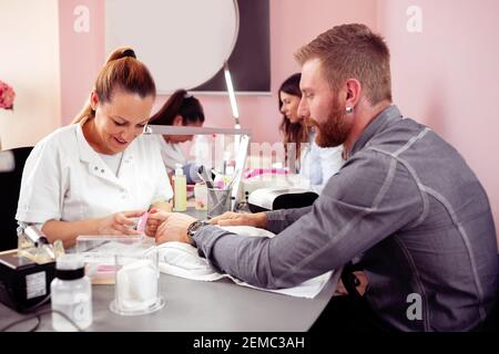 Homme dans un salon de manucure obtenant ses ongles en ordre, manucure pour les hommes Banque D'Images