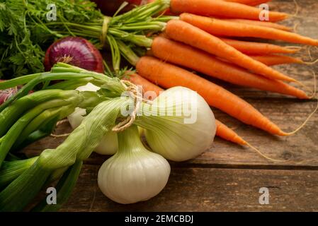 Bouquet de carottes fraîches sur fond rustique en bois. Oignons rouges sur bois rustique. Différents oignons sur bois. Oignon blanc sur bois. Banque D'Images