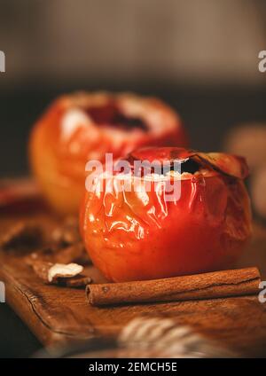 pommes cuites au four au fromage cottage avec baies et noix, recouvertes de miel et saupoudrées de cannelle. sur une surface en bois dans un style rustique Banque D'Images