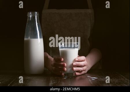 une femme paysanne verse le lait dans un verre Banque D'Images