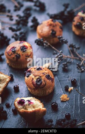 muffin aux raisins de corinthe sur fond sombre à côté des baies sur les branches. dans un style rustique. style sombre Banque D'Images