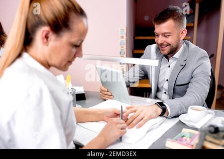 Beau type regardant ayant un traitement de manucure dans un ongle salon Banque D'Images