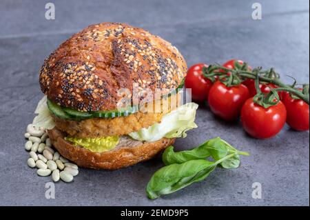 Délicieux déjeuner végétarien avec hamburger à base de légumes, petit pain bio aux graines et légumes frais du jardin et cafetière à friture française Banque D'Images