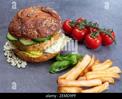 Délicieux déjeuner végétarien avec hamburger à base de légumes, petit pain bio aux graines et légumes frais du jardin et cafetière à friture française Banque D'Images