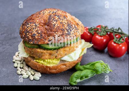 Délicieux déjeuner végétarien avec hamburger à base de légumes, petit pain bio aux graines et légumes frais du jardin et cafetière à friture française Banque D'Images