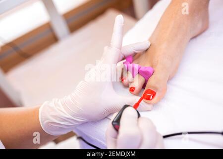 Application de vernis à ongles sur les ongles des orteils en salon de pédicure Banque D'Images