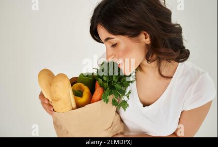 Brunette dans un T-shirt blanc mangeant des aliments sains Banque D'Images