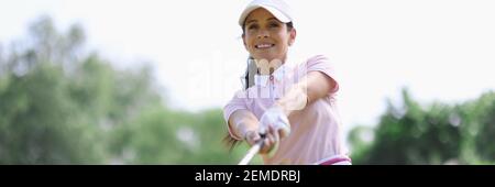 Femme golfeur avec putter dans la main après avoir frappé. Banque D'Images