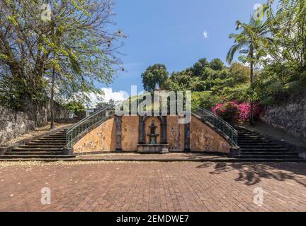 Escaliers éclairés au soleil, fontaine et bougainvilliers aux vestiges du Théâtre de Saint-Pierre, Martinique, à la suite de l'éruption du Mont Pelée en 1902 Banque D'Images