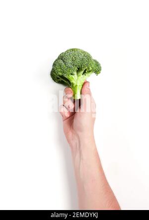 brocoli dans une main mâle sur fond blanc Banque D'Images