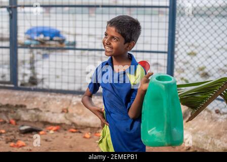 Varanasi. Inde. 10-02-2018. Portrait d'un enfant heureux à l'école tout en trouvant de l'eau. Banque D'Images