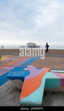 Brighton Royaume-Uni 25 février 2021 - UN coureur passe par la jetée ouest de Brighton sur une matinée calme et sombre le long de la côte du Sussex, mais le temps ensoleillé est prévu pour les prochains jours : Credit Simon Dack / Alamy Live News Banque D'Images