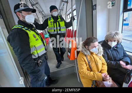 Prague, République tchèque. 25 février 2021. Des policiers, portant des respirateurs pour prévenir la propagation du coronavirus, vérifient les passagers dans le tramway à Prague, République tchèque, le 25 février 2021. Les respirateurs, les nano masques ou deux masques médicaux deviennent obligatoires dans les lieux publics, tels que les magasins, les transports publics et les hôpitaux. Crédit : vit Simanek/CTK photo/Alay Live News Banque D'Images