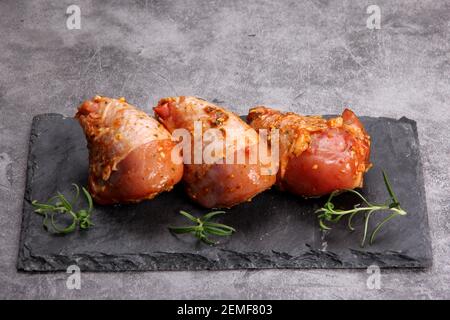 Cuisses de poulet crues marinées sur une casserole noire. Poulet mariné non cuit. Pilons de poulet marinés Banque D'Images