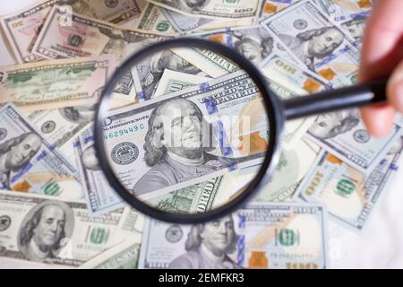 Loupe sur le fond d'un paquet de dollars sur la table gros plan, cent dollars washington, mille - texture, fond Banque D'Images