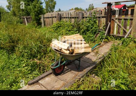 Chariot d'Agarden avec des supports en bois haché sur un pont en bois. Jour d'été. Banque D'Images