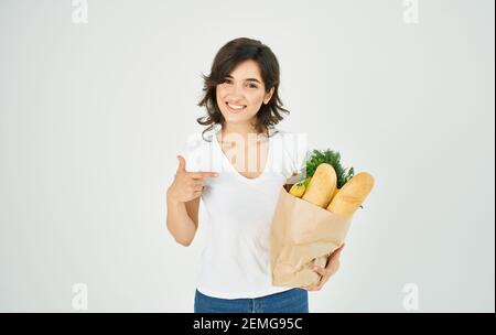 Brunette dans un T-shirt blanc mangeant des aliments sains Banque D'Images