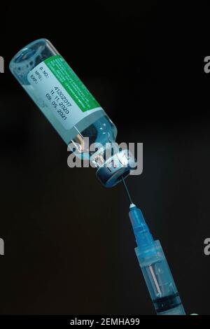 Une main gantée est vue en tenant une seringue et un flacon de vaccin contre le coronavirus Covishield à l'hôpital Madhyamgram. Les personnes de plus de 60 ans et les personnes de 45 ans atteintes de comorbidités peuvent se faire vacciner à leurs frais dans des cliniques privées à partir du 1er mars. Banque D'Images