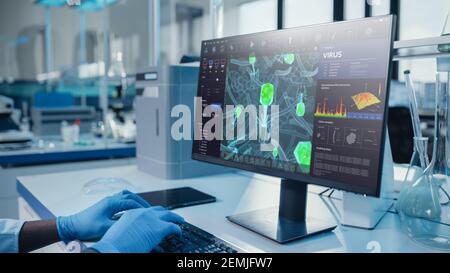 Laboratoire médical moderne: Scientifique portant des gants chirurgicaux, travaillant sur ordinateur, scren montre virus Research Software. Laboratoire scientifique avancé Banque D'Images