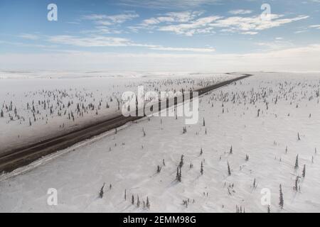 Vue aérienne en hiver de la route d'Inuvik-Tuktoyaktuk (construite au-dessus du pergélisol), en gravier toutes saisons de 139 km, dans l'Arctique canadien. Banque D'Images