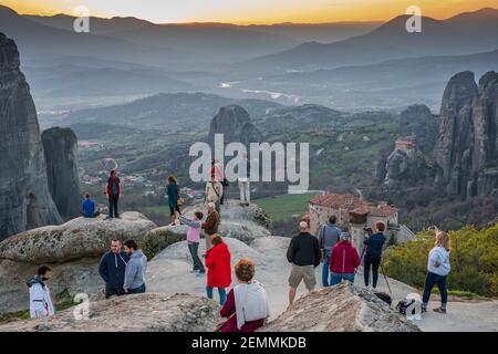 Les gens admirent la vue magnifique sur les monastères de Meteora au coucher du soleil. Banque D'Images