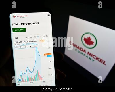 Personne tenant un téléphone cellulaire avec site Web et carte des activités minières Canada Nickel Company Inc. À l'écran avec logo. Concentrez-vous sur le centre de l'écran du téléphone. Banque D'Images