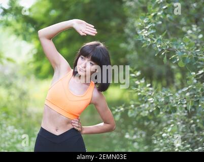 Jolie jeune femme moulante faisant des exercices à l'extérieur Banque D'Images