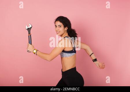 Jeune fille professionnelle; réparer ses propres choses. Femme avec des compétences pour réparer des machines cassées. Entretien fille. Jeune homme avec une clé Banque D'Images