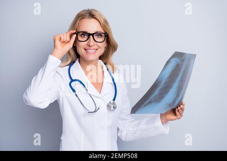 Photo de la jolie personne gaie main tactile lunettes look appareil photo maintenir les rayons x isolés sur fond gris Banque D'Images