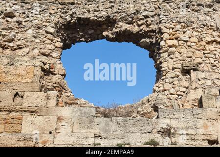 trou rond dans l'ancienne forteresse médiévale mur à travers lequel le ciel est visible Banque D'Images