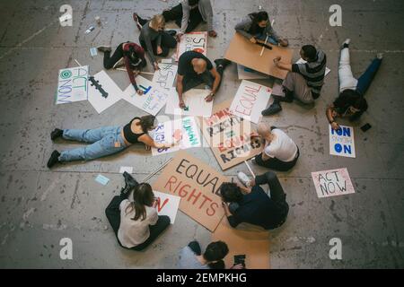 Directement au-dessus de l'homme et de la femme protestataire préparant des affiches pour mouvement social Banque D'Images