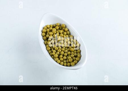 Olives vertes marinées dans un bol en céramique blanche Banque D'Images