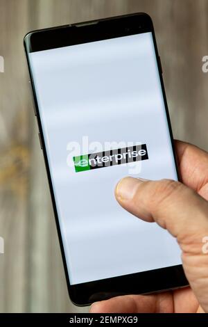 Un téléphone mobile ou mobile détenu par un Ouvrez l'application Enterprise car Rent à l'écran Banque D'Images