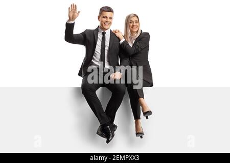 Homme et femme professionnels dans des vêtements d'affaires assis sur un panneau vierge et revêtement isolé sur fond blanc Banque D'Images