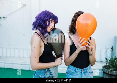 Deux amies s'amusent avec des ballons colorés. Arrière-plan blanc non isolé Banque D'Images