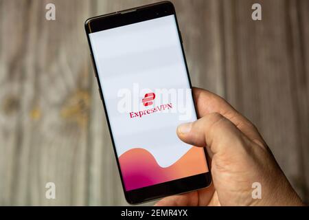 Un téléphone mobile ou mobile détenu par un Main avec l'application Express VPN ouverte à l'écran Banque D'Images