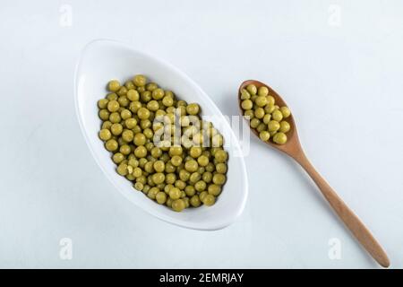 Bol blanc et cuillère en bois avec olives vertes marinées Banque D'Images