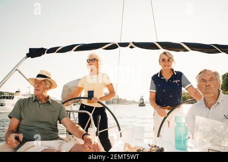 Heureux couples seniors naviguant en bateau le jour ensoleillé Banque D'Images