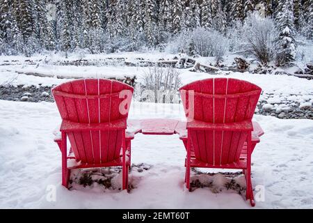 Deux chaises Adirondack rouges à proximité de la rivière Maligne en hiver Banque D'Images