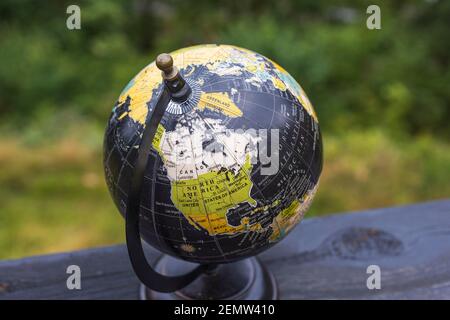 Gros plan sur le tour de la main autour du globe scolaire coloré. Banque D'Images