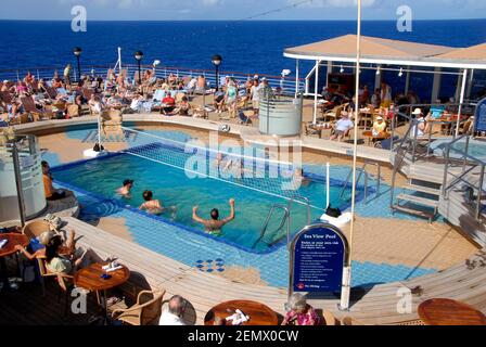 Des gens sur un paquebot de croisière regardant un match dans la piscine du navire, Caraïbes Banque D'Images