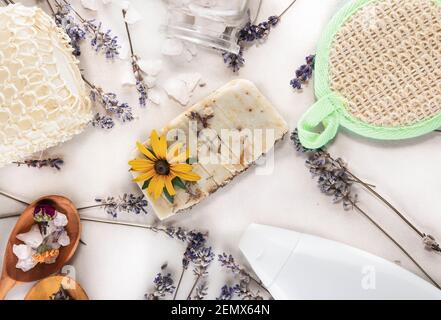 Savon fait main à base d'herbes et d'huiles, lavande, débarbouillettes, sel de mer et une bouteille d'huiles pour les soins de spa sur fond blanc. Savon à base de natura Banque D'Images