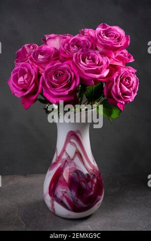 Roses rouges-roses dans un coffret en verre Adrian Sankey art. Roses ouvertes après 11 jours dans vase. Banque D'Images
