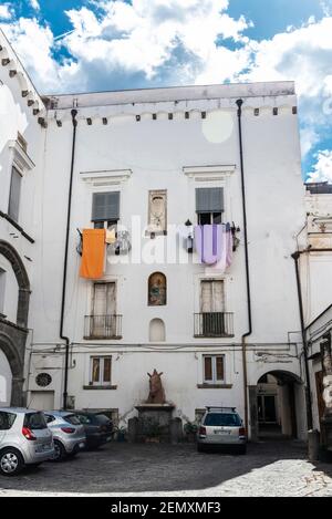 Naples, Italie - 9 septembre 2019 : patio de bâtiments classiques avec voitures garées et vêtements suspendus sur le balcon de Naples, Italie Banque D'Images